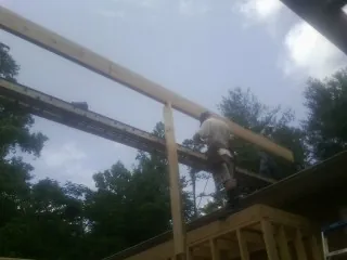 Carpenter setting a ridge beam over a new addition frame — Ice Dam Removal by Roofing Brothers in Havertown