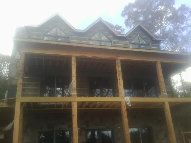 Dormers and porch framing on a large log home under construction — Roof Coating work by our crew in Havertown