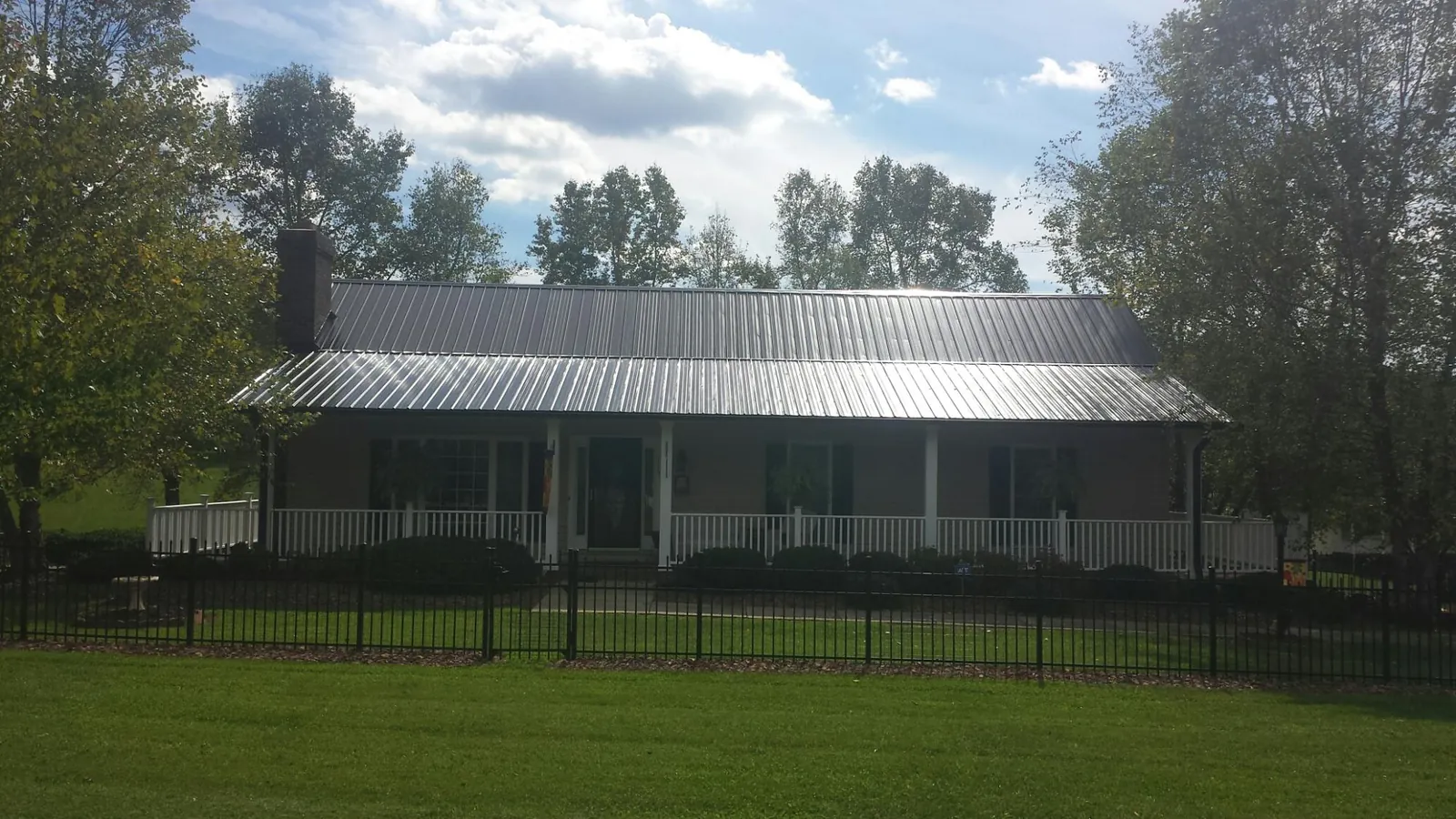 Gray metal roof on a brick ranch with a full width front porch — Gutter Guard Installation work by our crew in Havertown